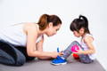 Mother helping kid with shoes.