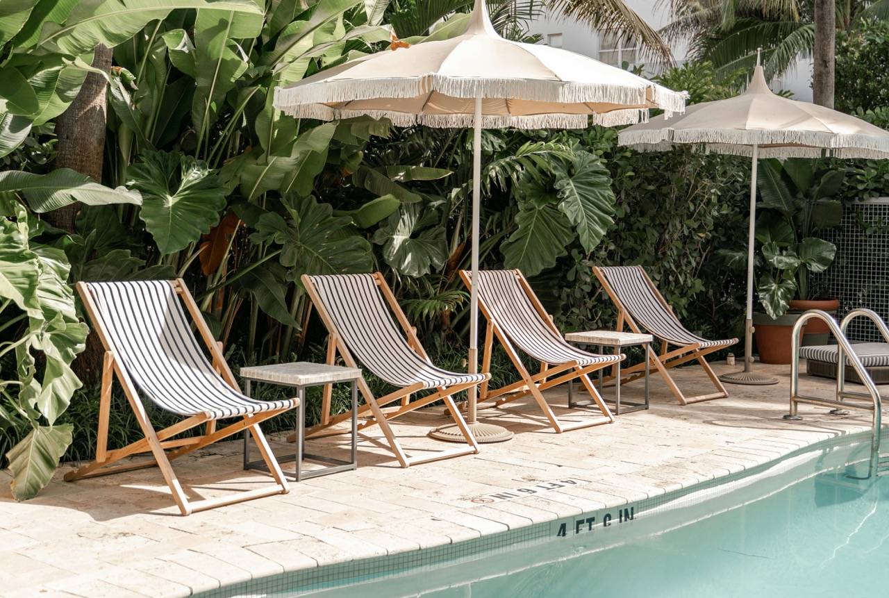 Striped lounge chairs and umbrellas beside a pool.