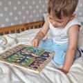 Little boy playing with the Montessori Alphabet Parking Maze toy.