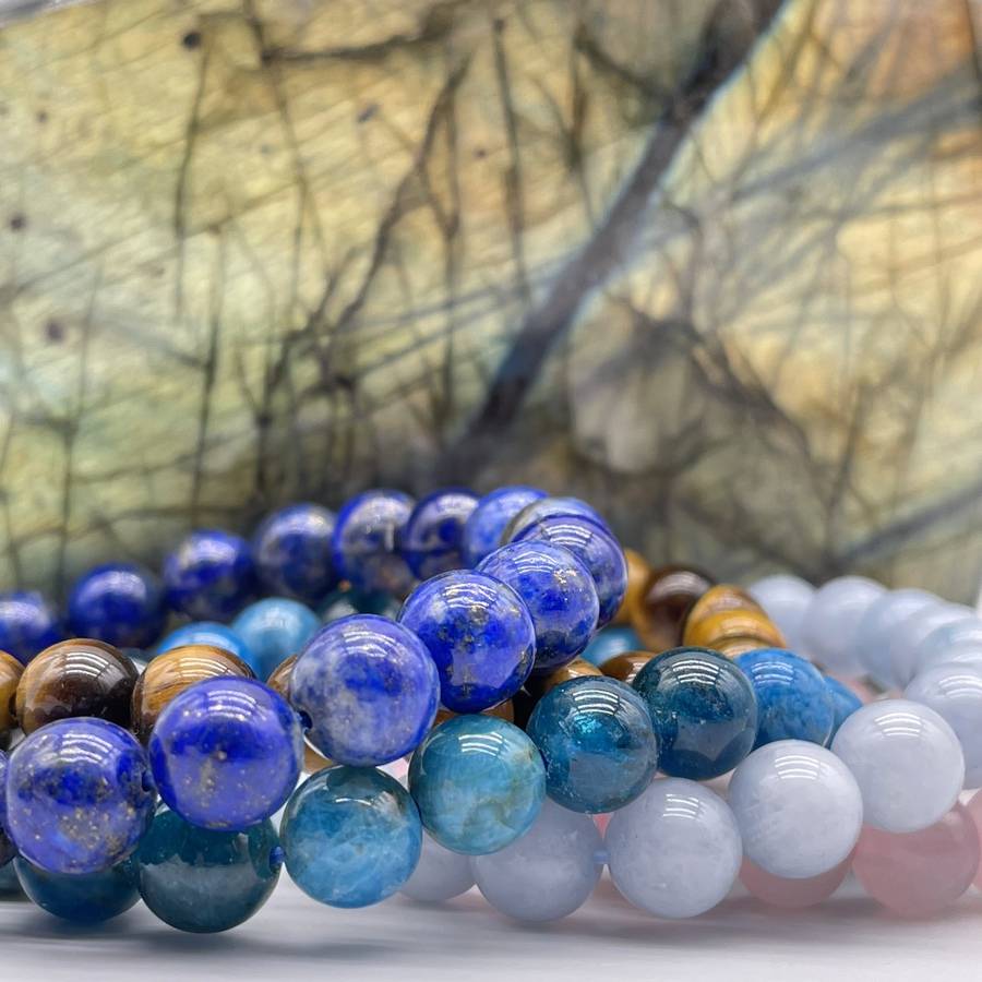 bracelets en pierres naturelles de lapis lazuli, oeil de tigre, apatite bleue, calcédoine, quartz rose avec un bloc de labradorite en fond