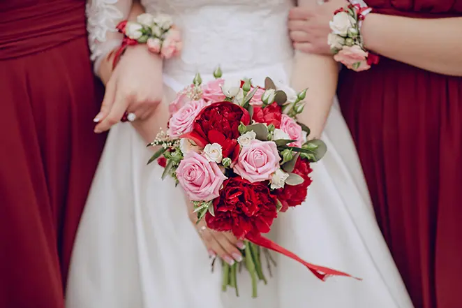 Gros plan sur la mariée tenant le bouquet de mariage avec les demoiselles d'honneur.