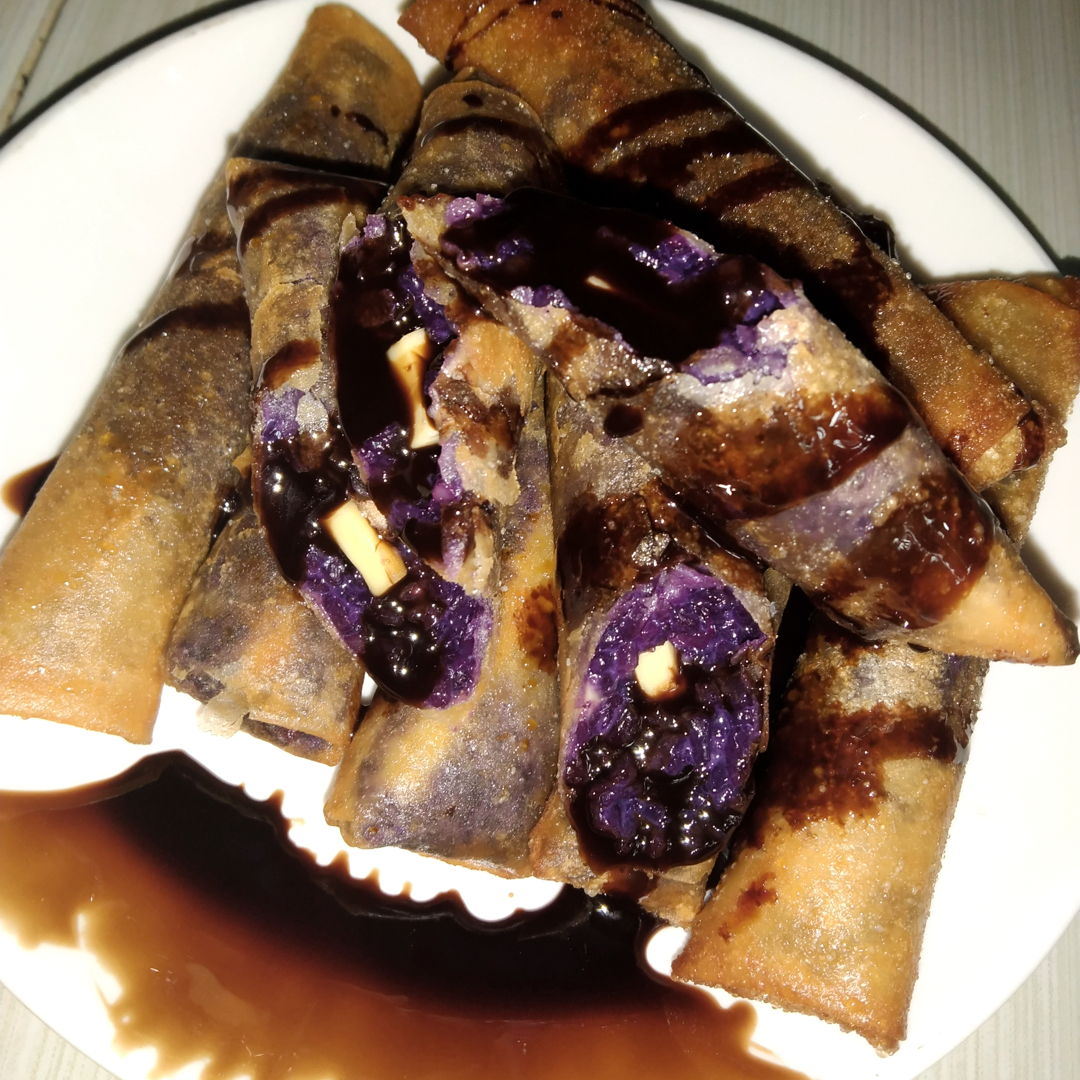 It's a filipino dessert.We called it 'Ube turon malagkit with cheese' (glutinous rice with flavored condensed and has a cheese in side)Drizzle with a chocolate syrup on top..so yummy 😋
