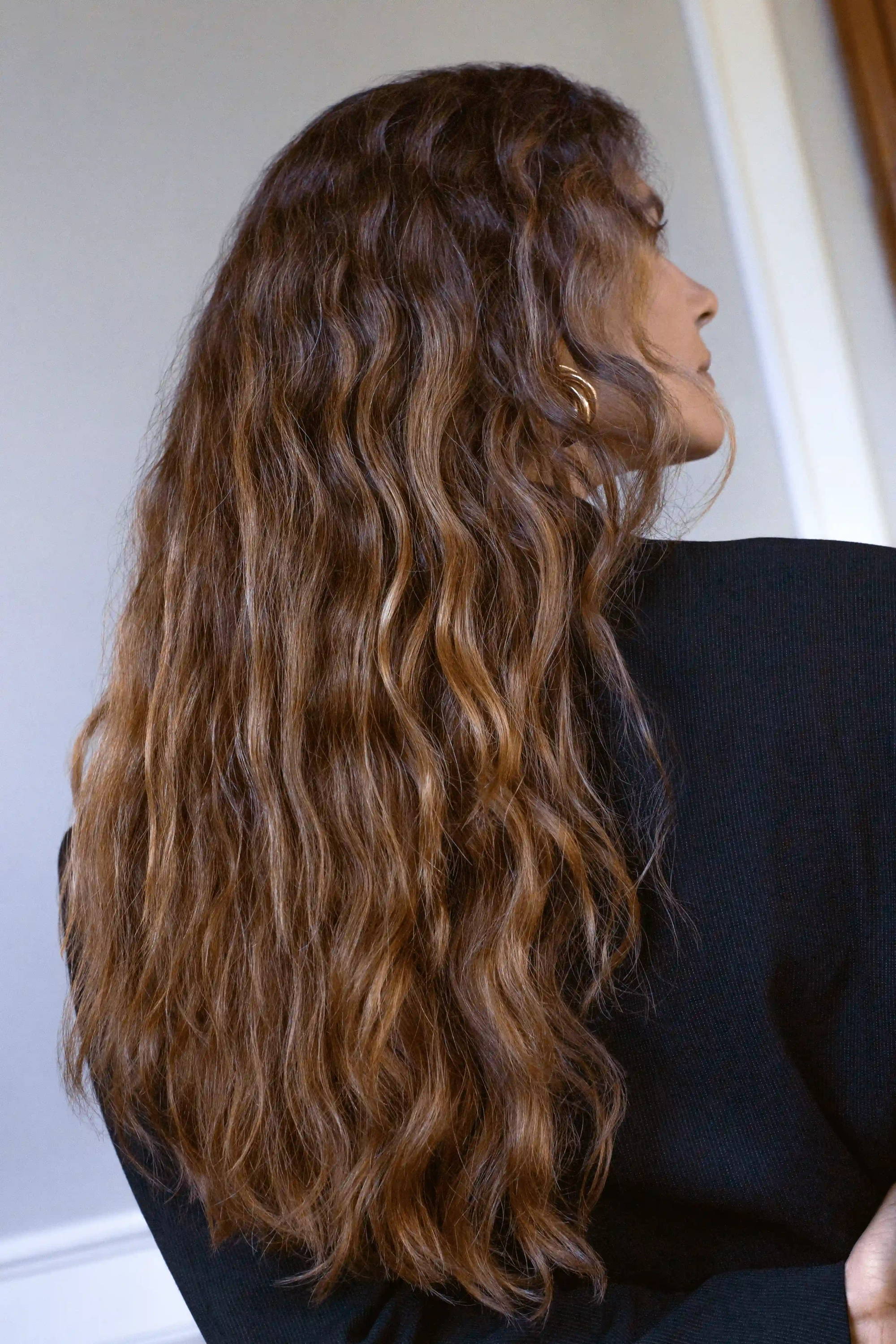 Frau mit Locken pflegt ihr Haar im Sommer