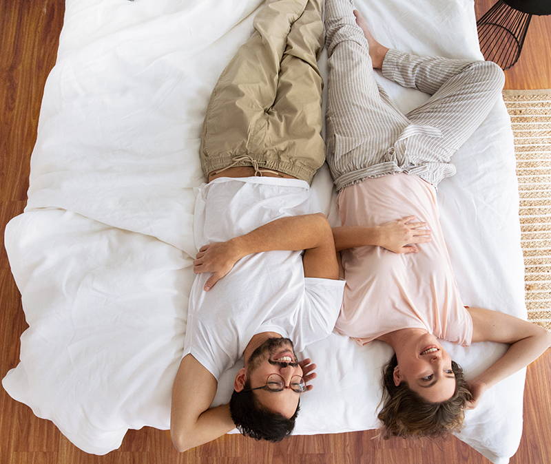 Man and woman lying on Real Bed. Image