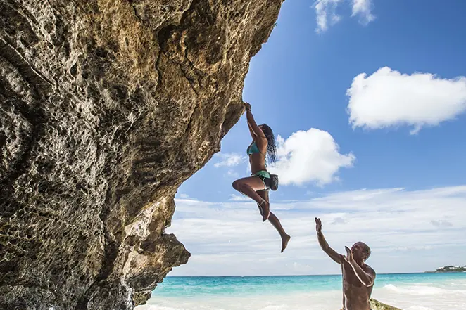 Un couple en train de faire une escalade sur une plage aux Bermudes