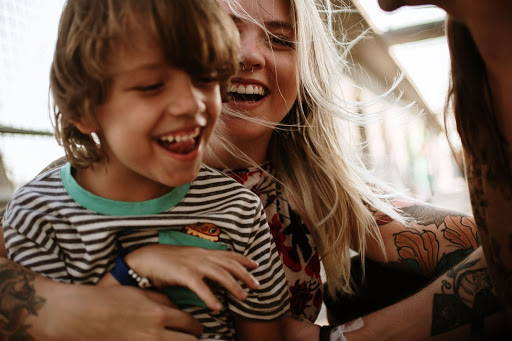 A woman and a boy hugging and smiling - Photo by Ana Bregantin from Pexels