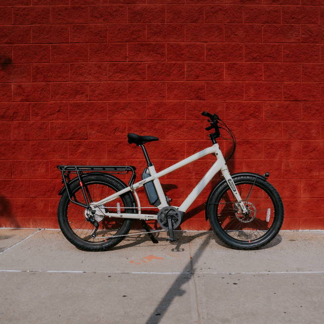 a city bike with a rack in front of a red wall
