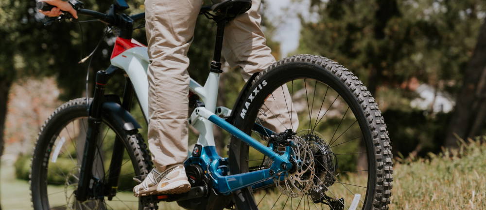 a man riding a blue and white Cannondale Moterra full suspension electric mountain bike