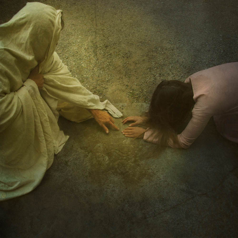 Jesus drawing in the dirt in front while the woman accused of adultry is kneeling.