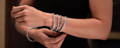 Woman with a stack of diamond and sapphire eternity bracelets on her wrist.