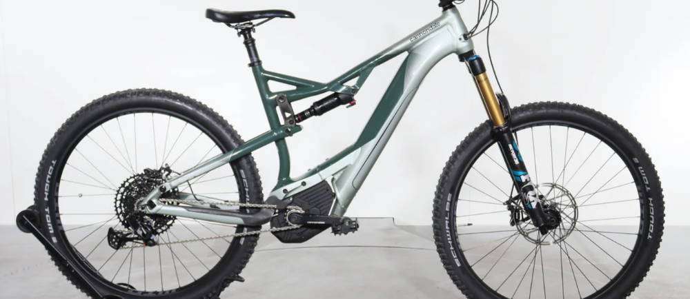 A silver and green Cannondale Moterra 1 full suspension electric mountain bike