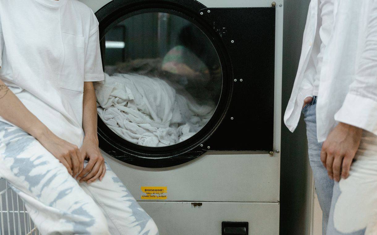 two men in white in front of a washing machine
