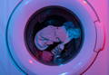 Un lave-linge chargé vue de face avec des vêtements dedans