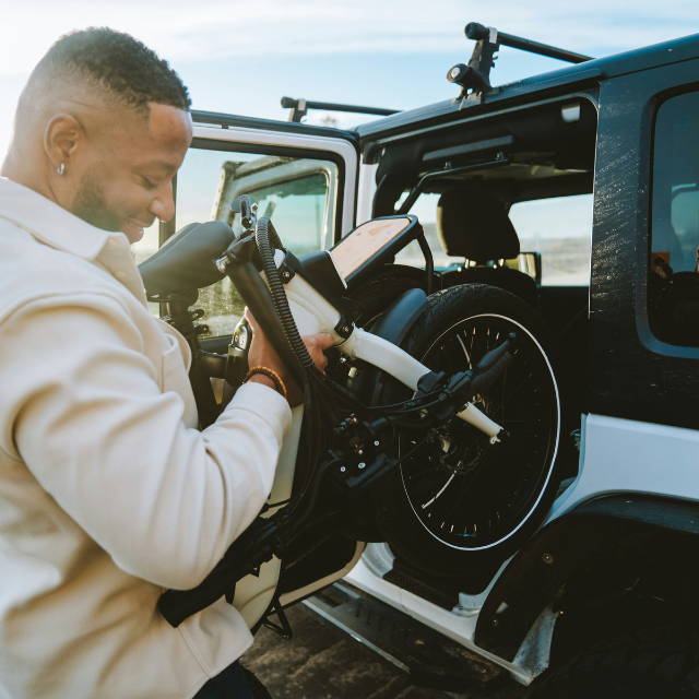 Man lifting folding ebike into car