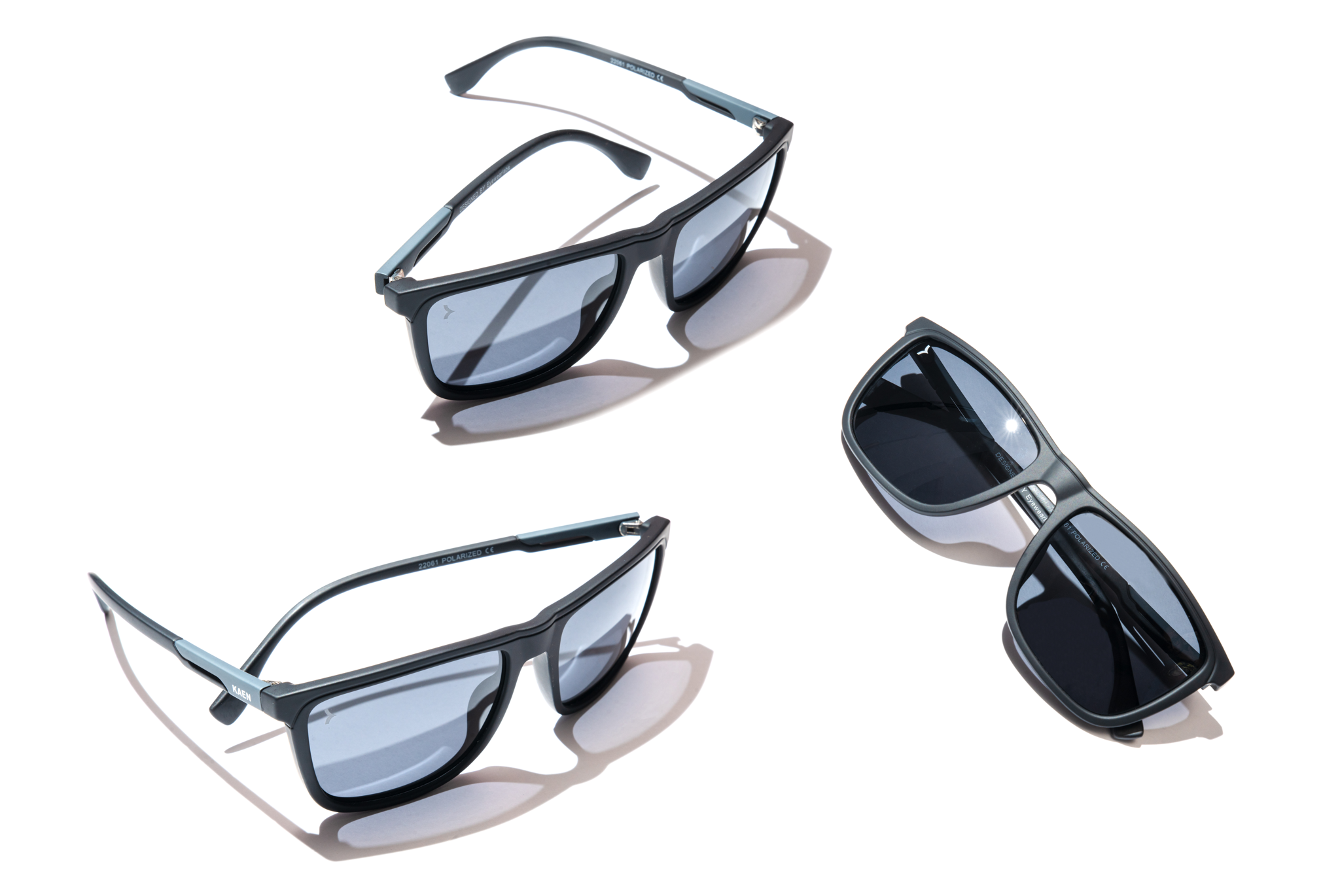 Three pairs of sunglasses in a row on a white background. From left to right, the first pair has a black frame and gray lenses, the second pair has a tortoiseshell frame and brown lenses, and the third pair has a gold frame and mirrored lenses.