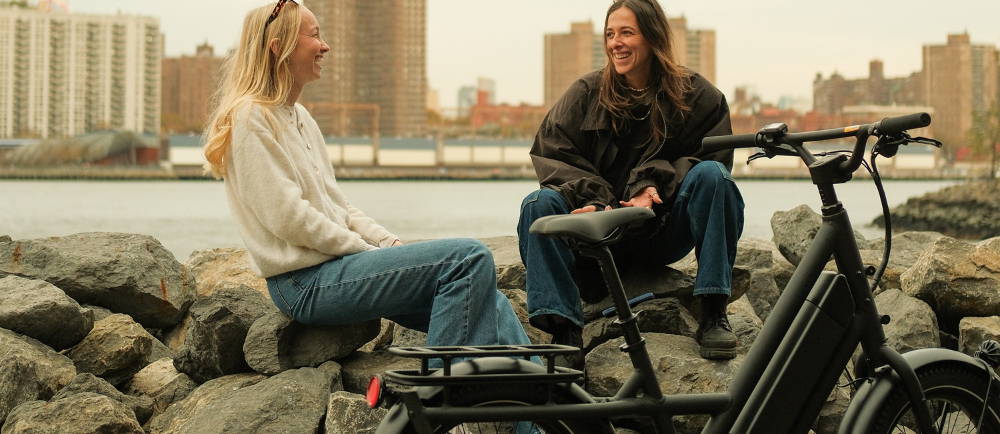 Two woman sitting next to Specialized Globe Haul electric cargo bike