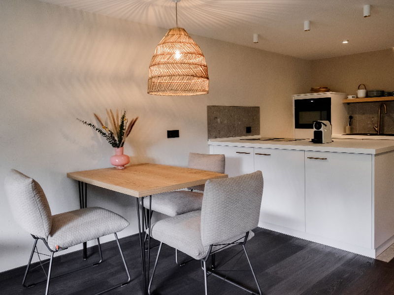 Essbereich mit Holztisch und offener Küchenzeile im modernen Apartment von Hugo & Pepi in Mittelberg
