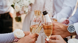 Photo des gens prenant un verre lors d'un mariage sur la plage.