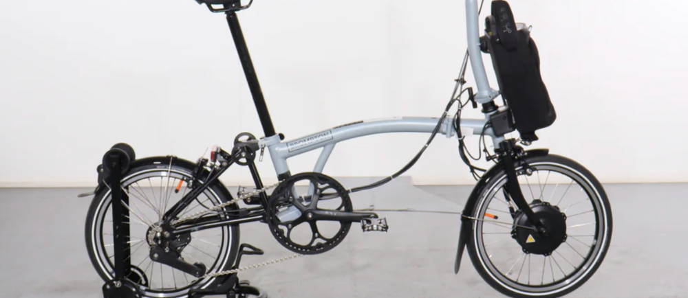 An off white Brompton P Line Electric 4 Speed electric folding bike