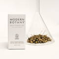 Modern Botany Multi-tasking Oil packaging next to a conical flask with dried flax inside.