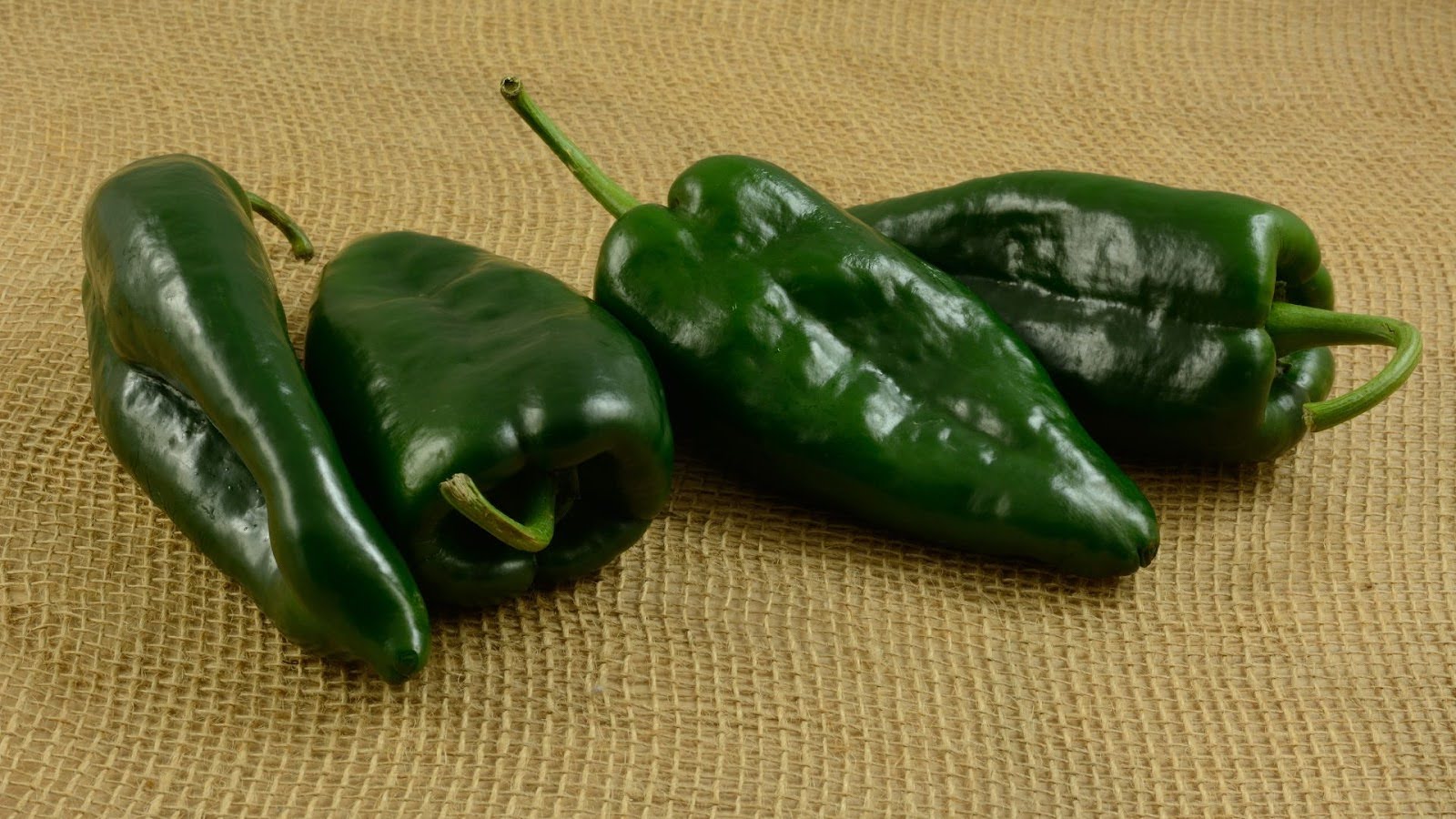 Green poblano peppers on a burlap background