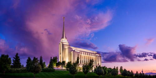 Photo of the Rexburg LDS Temple standing against a purple and blue sky.