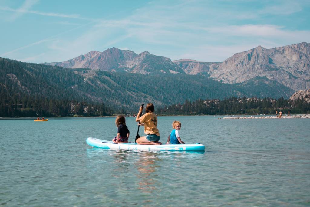 Families Inflatable paddleboarding in Canada lake