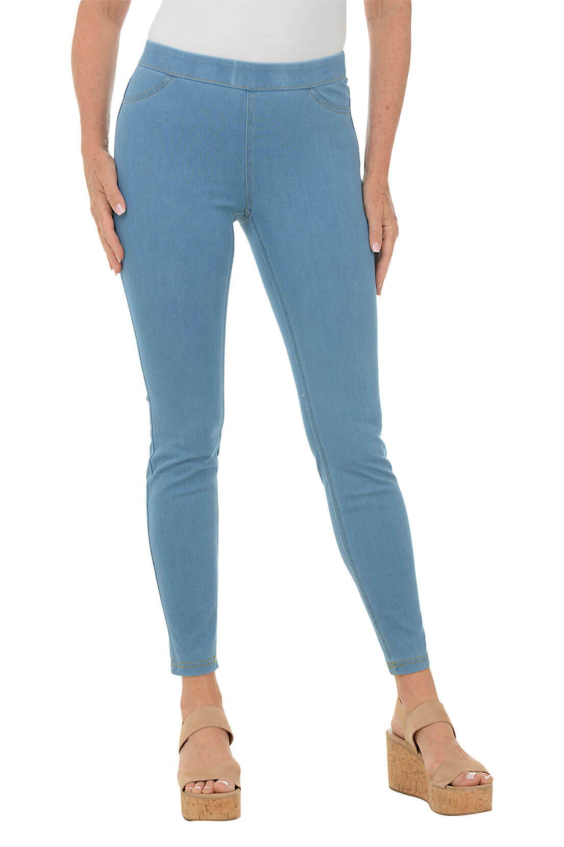 A woman wears a light blue jegging against a white background