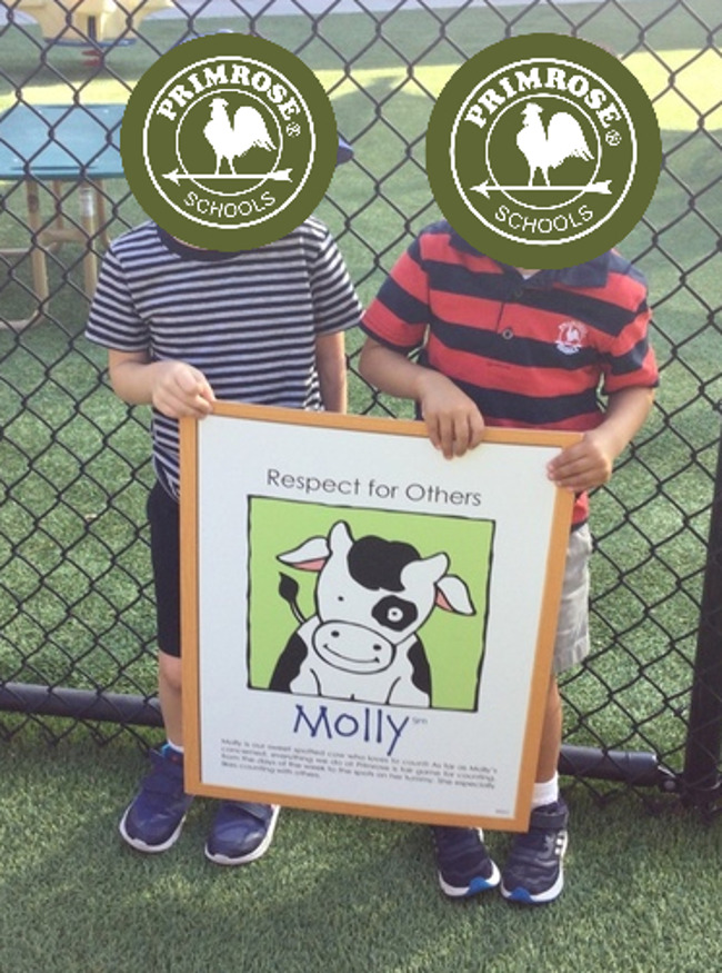 2 primrose students holding up a sign for molly the cow