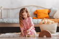 Little girl playing with Montessori wooden blocks.