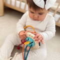 A Silicone Pulling toy for babies placed in a beautiful beige bag.