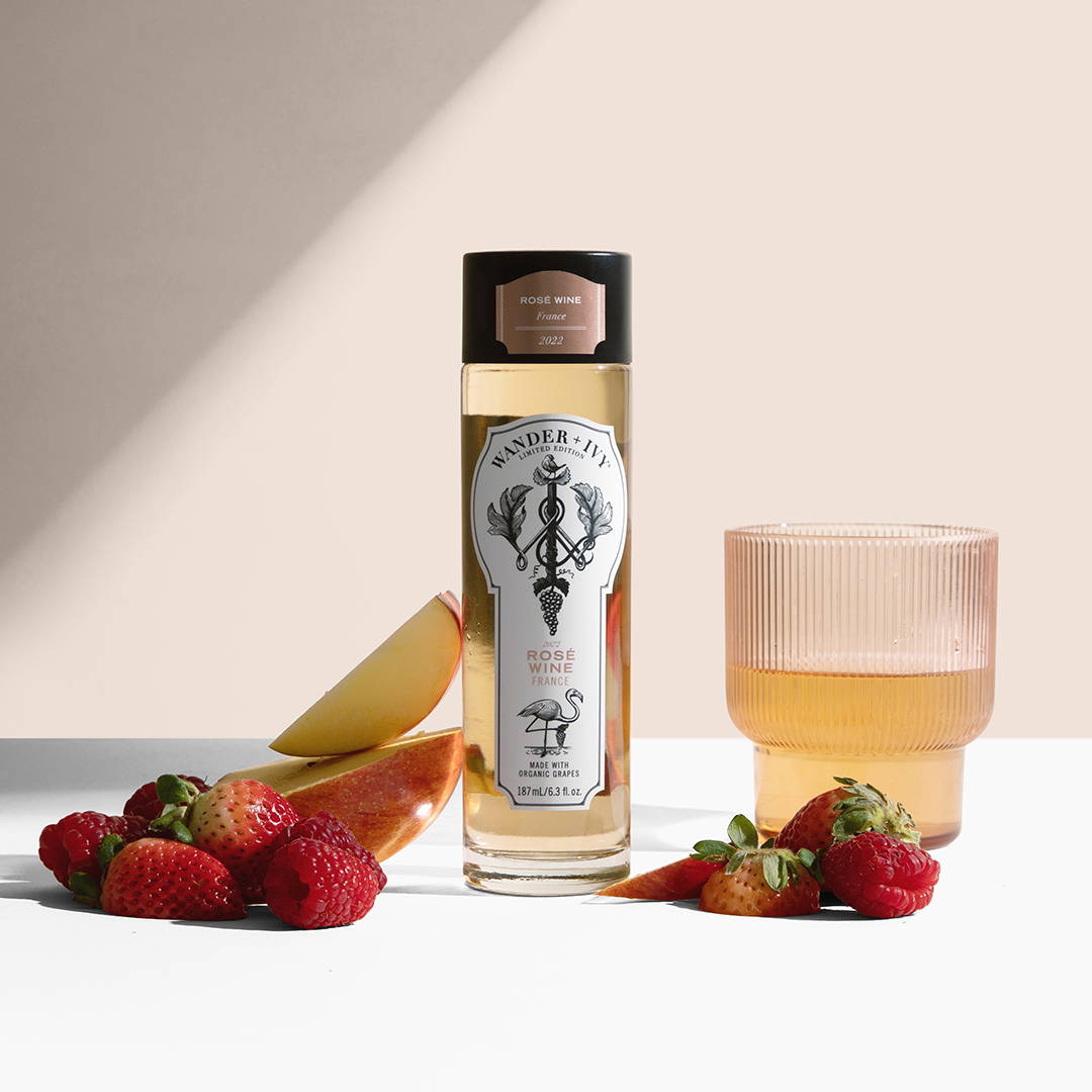 A single-serve bottle of Rosé with sliced apples and strawberries
