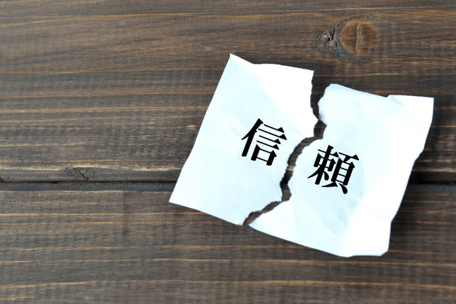 「信頼」と書かれた紙が破れている