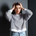 fear_striken_female_in_black_white_shirt_holding_head fear_striken_female_in_black_white_shirt_holding_head