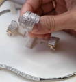 Reasons to Sell Gold and Silver Jewellery A hand holding a wide silver diamond ring above matching earrings and a necklace set