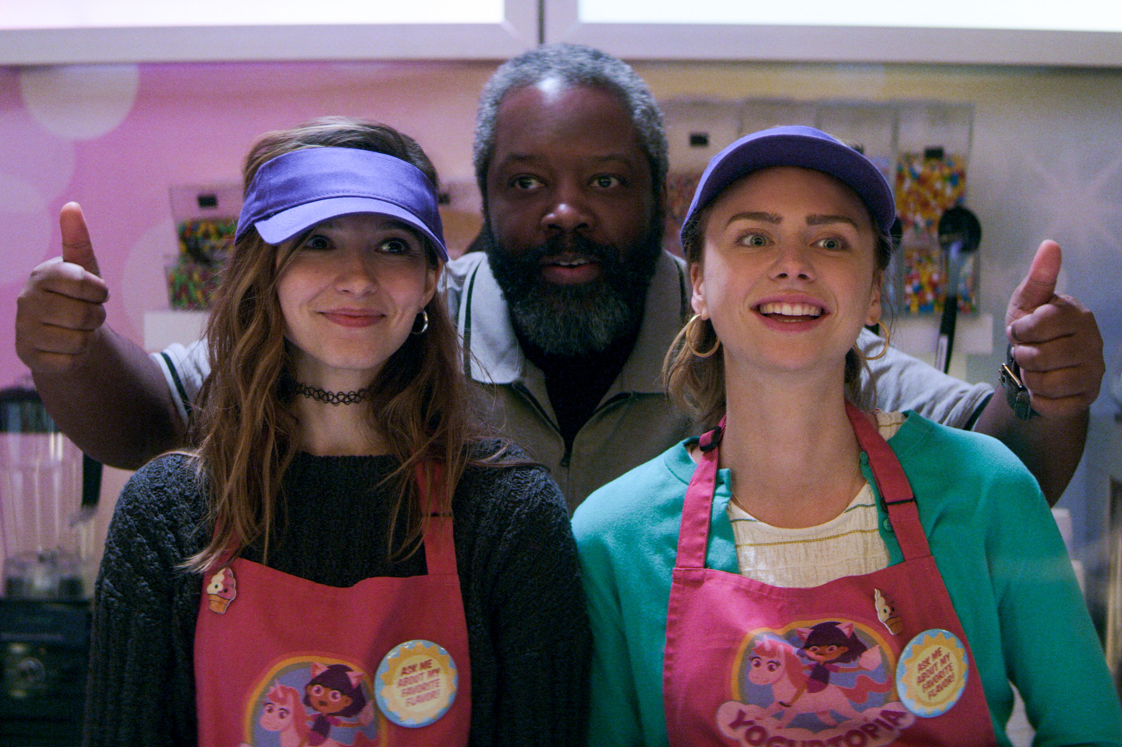 Blair Wesley, Terrance Coin, and Sterling Wesley smiling and working in a frozen yogurt shop.