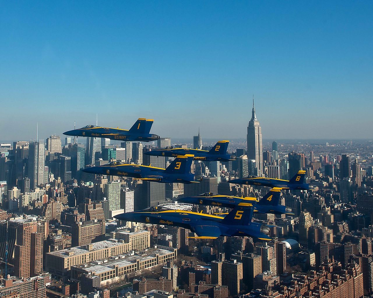 acrobatic aircraft in formation above a city
