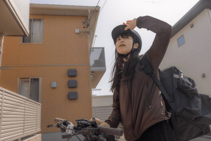 ヘルメットをかぶり自転車を押す女性