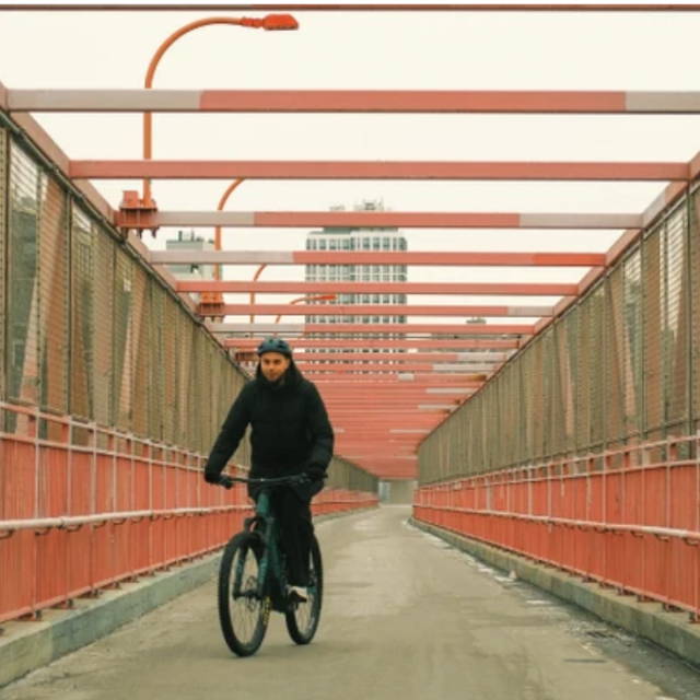 a man riding an electric bike across a bridge in new york city