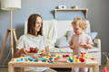 Mother and her daughter playing with Montessori toys. 