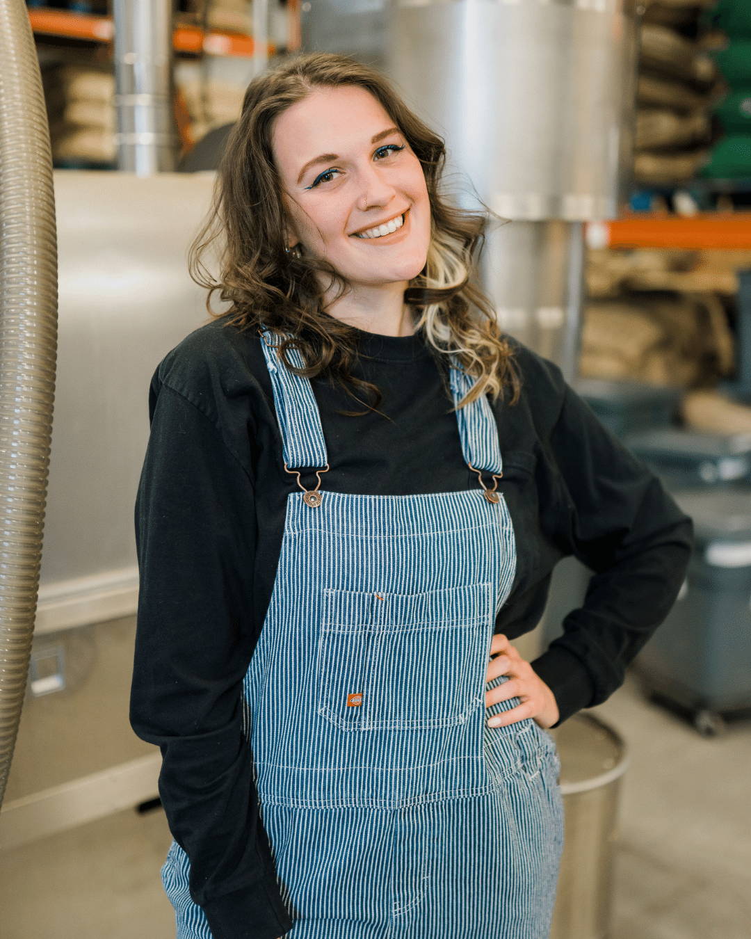 Woman with overalls smiling. 