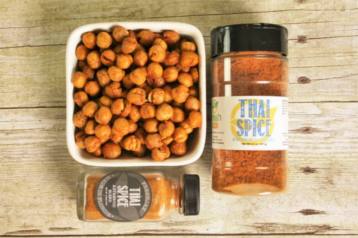 A bowl of thai spice chickpeas with a sampler bottle under it and a large bottle of FreshJax Organic Thai Spice next to it.