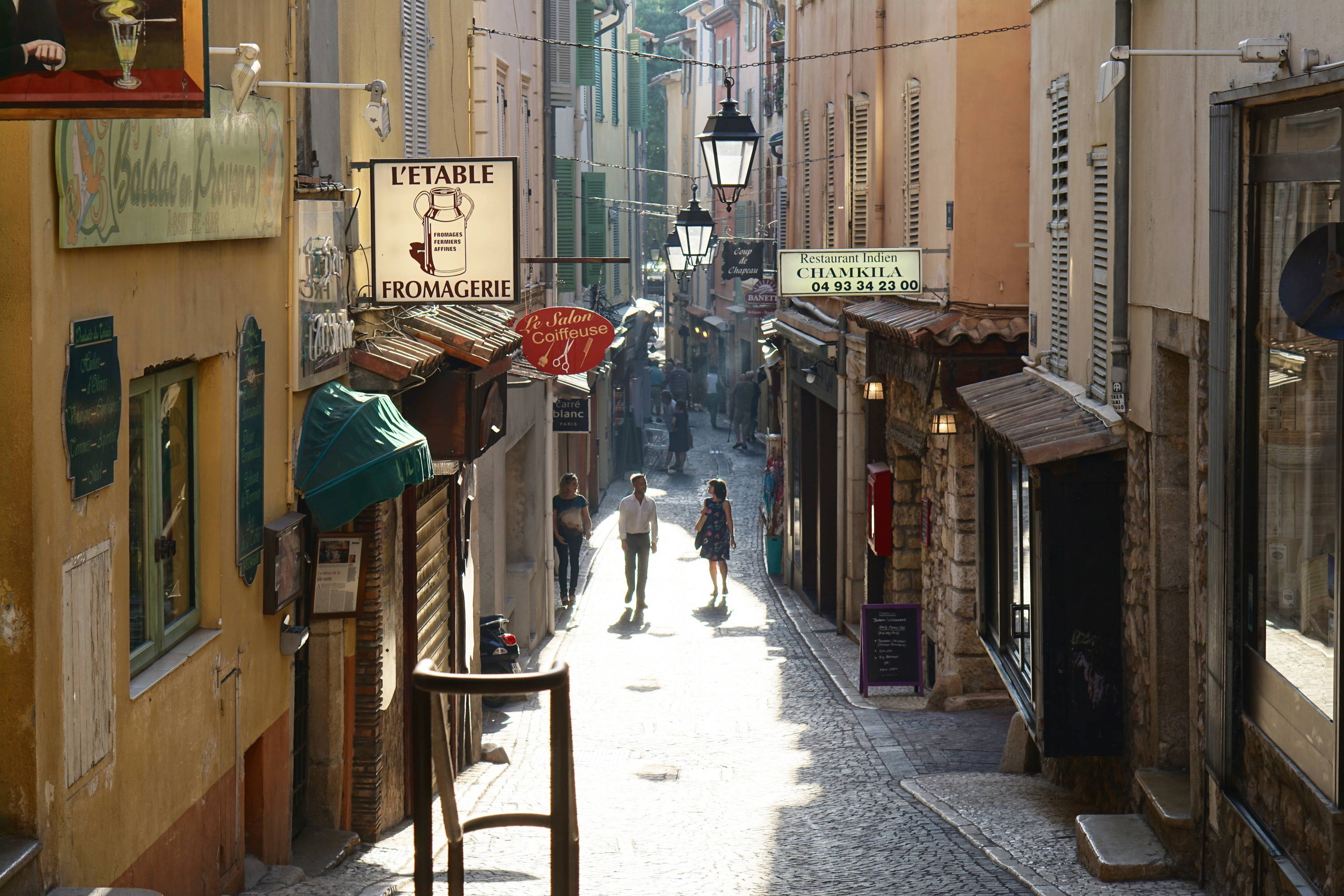 French city centre side walk surrounded by wine shops and fromageries. 