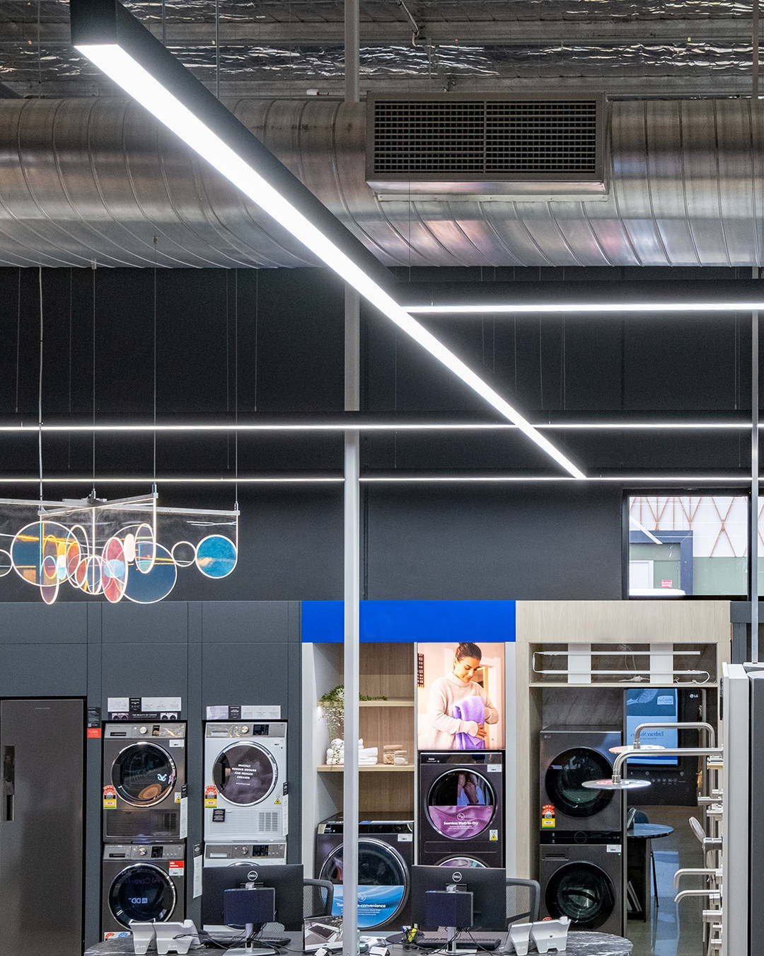 Energy-efficient pendant lighting by Havit Commercial used to tie together separate zones in a large open-plan store.
