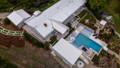 Aerial view of a residential property showcasing outdoor lighting, pool lighting, landscape lighting and illuminated pathways.
