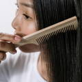 woman combing thin black hair
