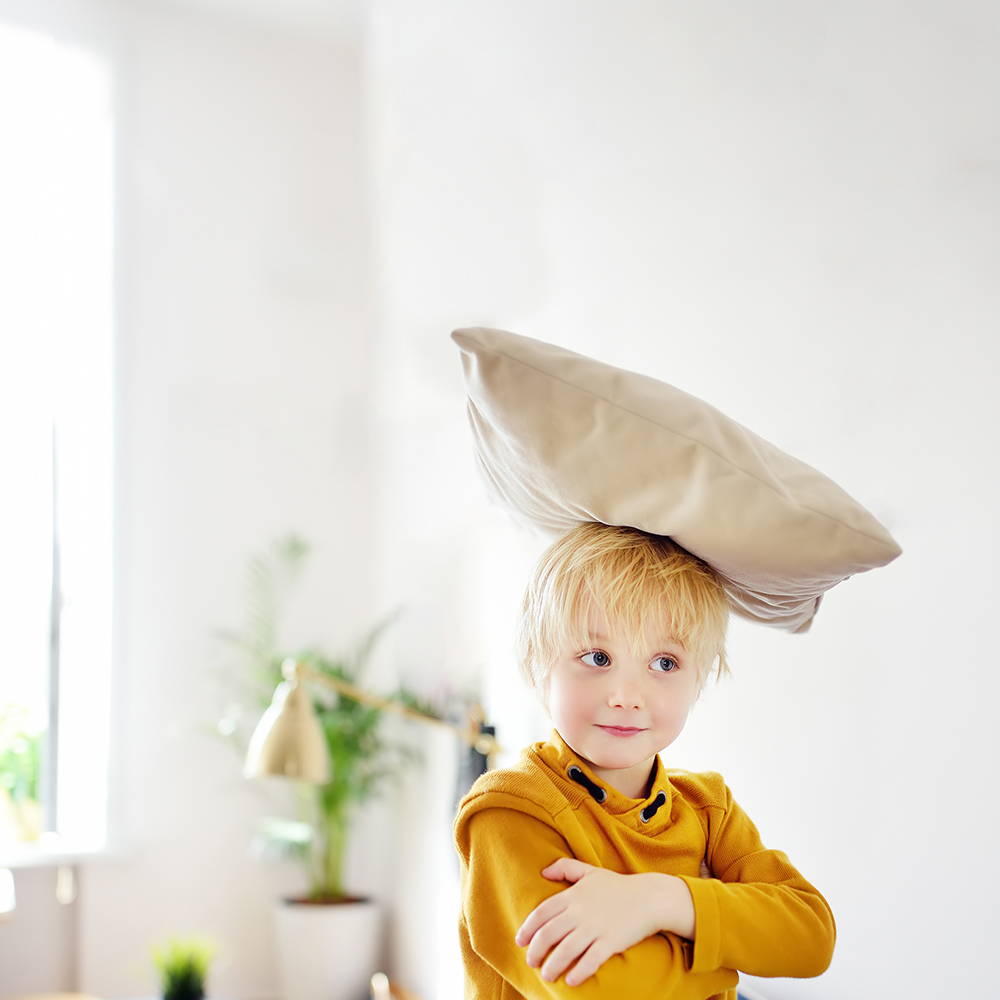 child with sofa cushion