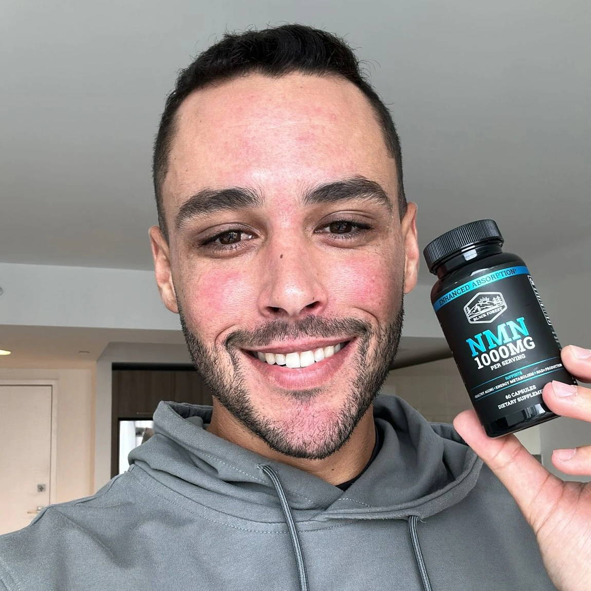 a guy holding a Black Forest NMN Bottle