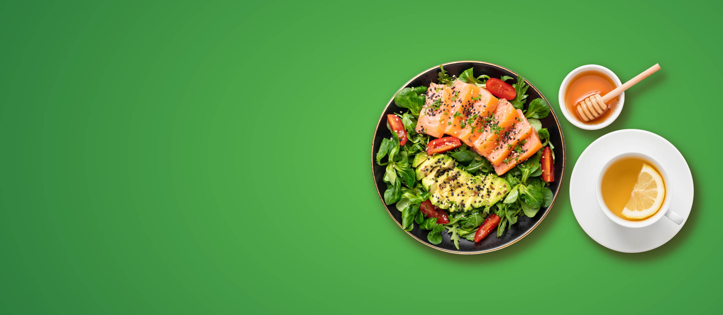 A salad with avocado and salmon next to a cup of green tea and a bowl of honey for Confetti's Virtual Nutrition Class