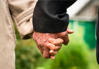 Plan rapproché de mains de personnes âgées qui se tiennent par la main.